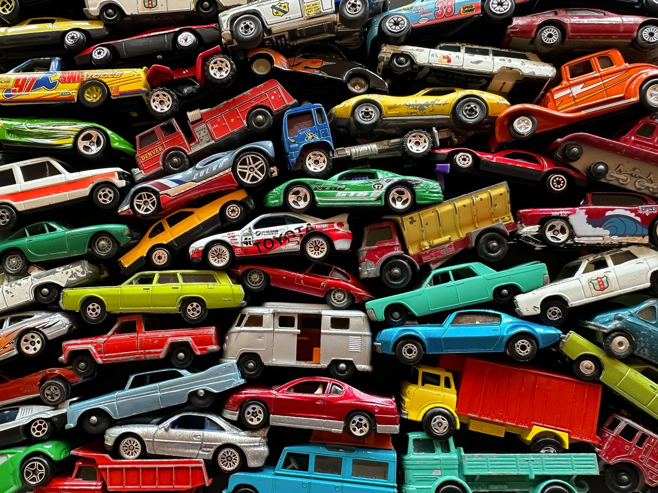 team-04 An organized assortment of miniature toy cars displayed in a vibrant and colorful arrangement.